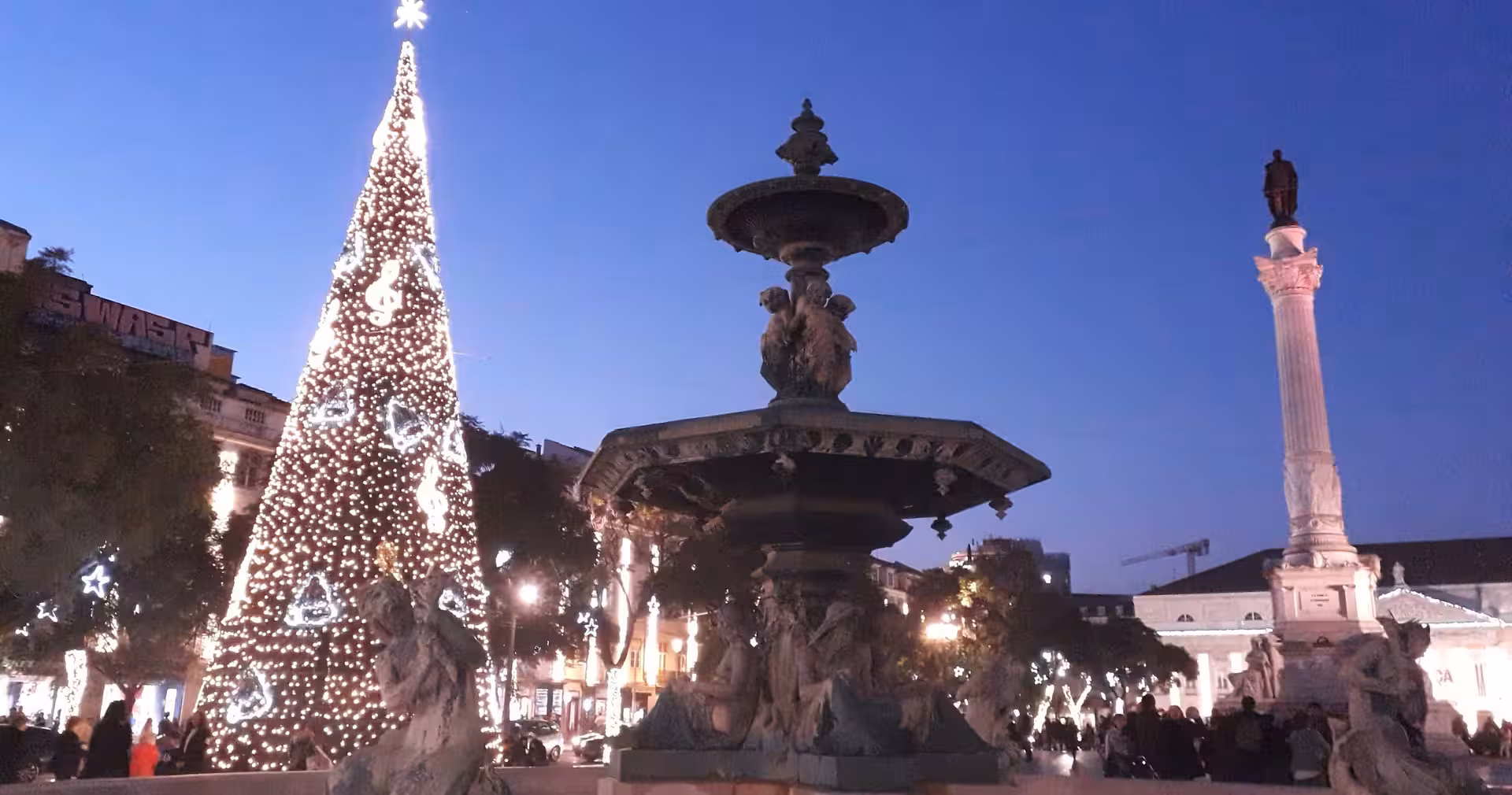 Evening at Rossio Square fountain with Christmas tree lights, Lisbon & Sintra full-day tour historic sights
