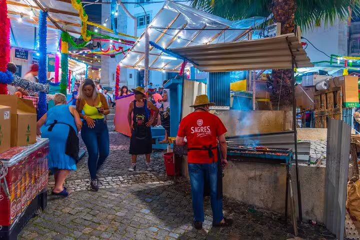 Local vendors and visitors enjoy a vibrant evening street market in Lisbon, showcasing authentic Portuguese culture and cuisine.