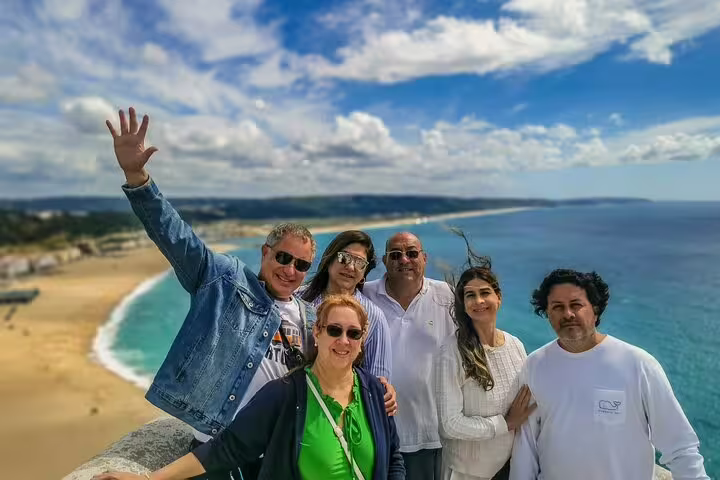 Group of tourists enjoying a scenic view of the beach and ocean during a 3-day tour of World Heritage Sites near Lisbon, Portugal.
