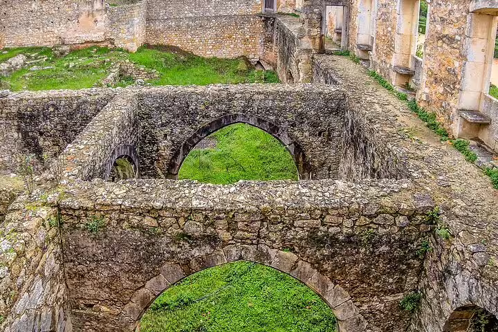 Ancient stone arches and walls of a historic ruin near Lisbon, showcasing Portugal's World Heritage Sites on a 3-day tour.