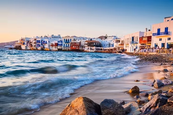 Little Venice Mykonos waterfront at sunset with waves and seaside cafes, private day trip from Athens