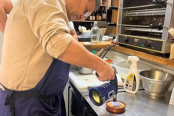 Local chef in Marseille torching a Provençal dish during hands-on cooking workshop in a professional kitchen