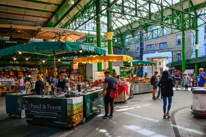 Bustling scene at London's Borough Market with vibrant stalls and visitors, showcasing the dynamic atmosphere of Camden Town and Downtown.