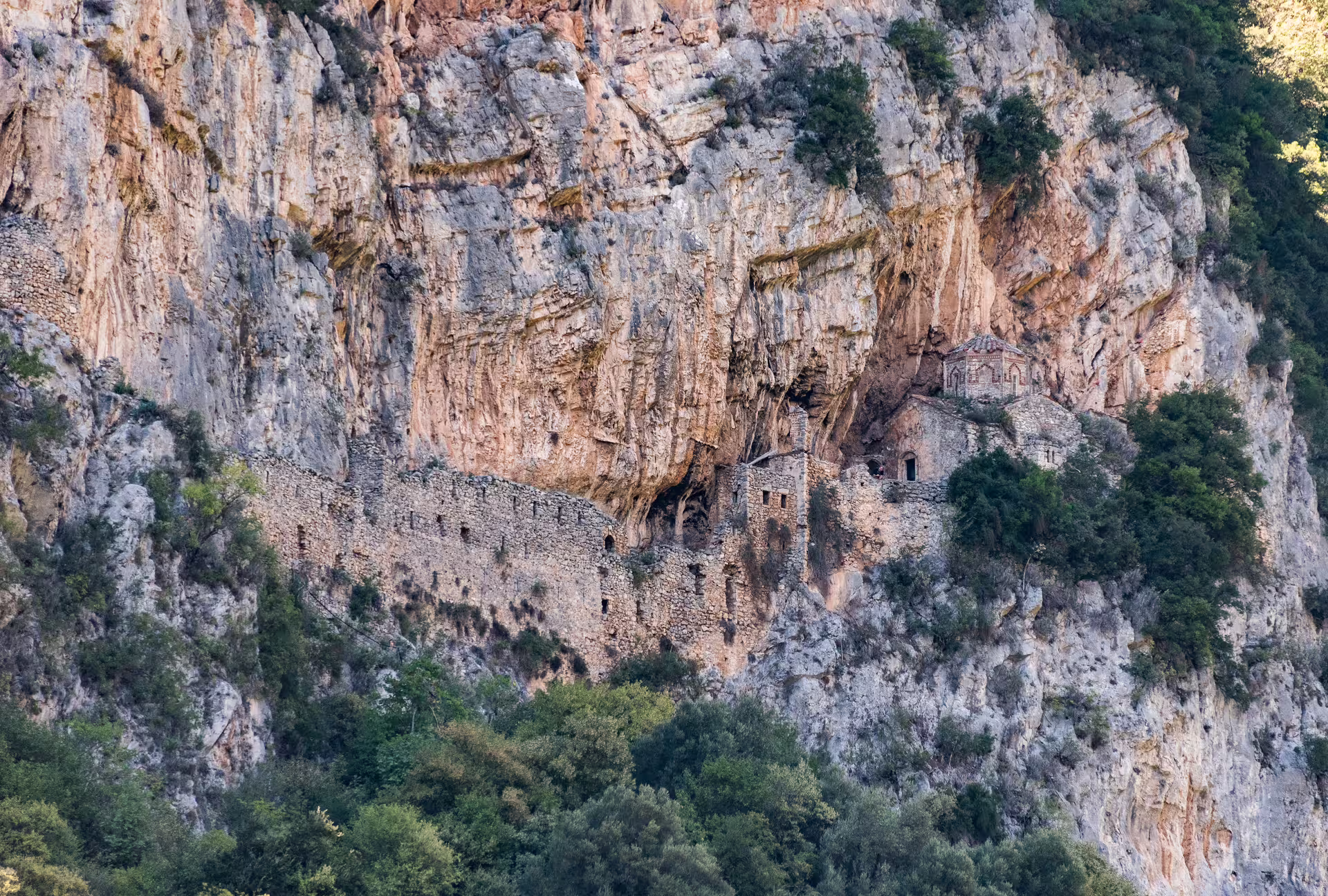 Ancient cliffside monastery and stone ruins in Lousios Gorge, Peloponnese, on a guided hiking tour