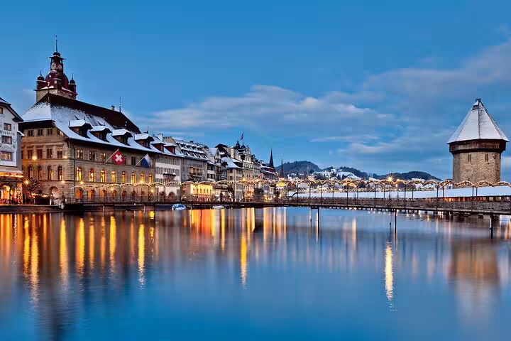 Evening view of Chapel Bridge and historic buildings in Lucerne, ideal for Swiss Travel Pass customizable tours.