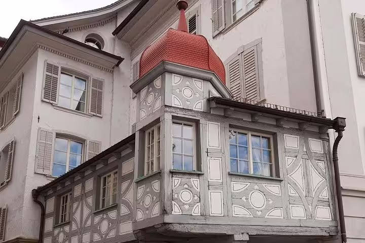Historic Lucerne building with unique architectural design featuring ornate wooden carvings and colorful details.