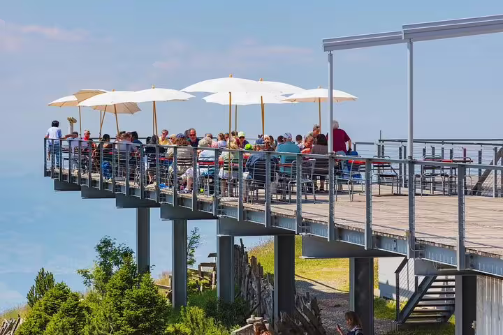 Visitors enjoy dining with stunning views from a terrace at Mount Rigi, a highlight of the Lucerne day trip.
