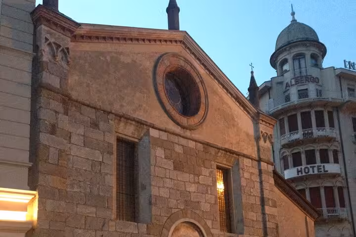 Lugano city tour stop at Chiesa di Santa Maria degli Angioli with nearby Hotel Albergo facade in Lugano