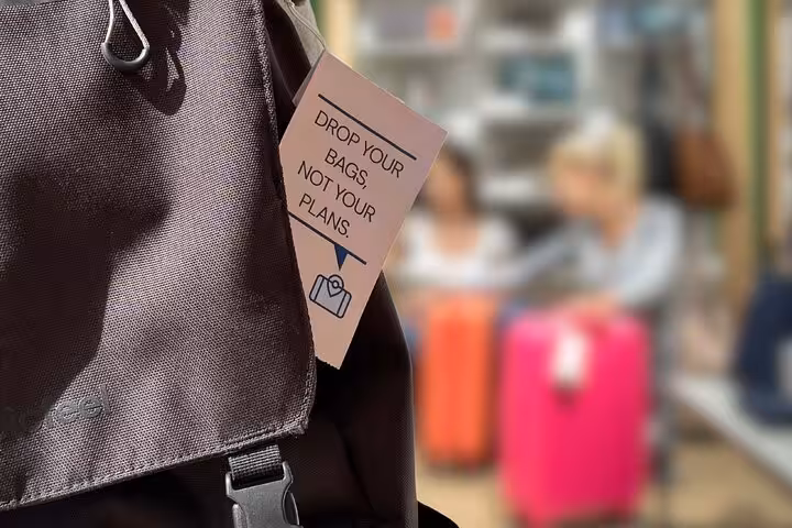Backpack with “Drop your bags” tag, promoting secure luggage storage near Place de la Nation, Paris