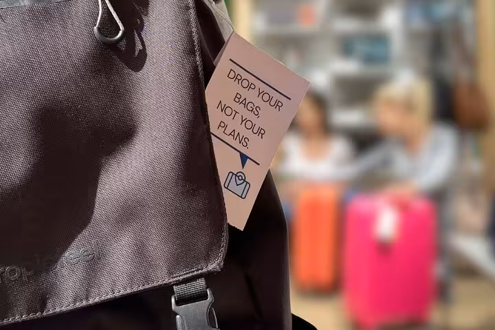 Close-up backpack tag “Drop your bags” promoting secure luggage storage near Musée des Arts et Métiers, Paris