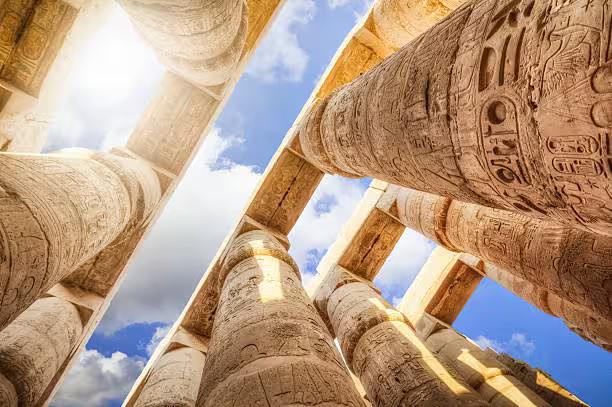 Luxor Karnak Temple columns with hieroglyphs and blue sky, part of 5-day Cairo Luxor Abu Simbel tour