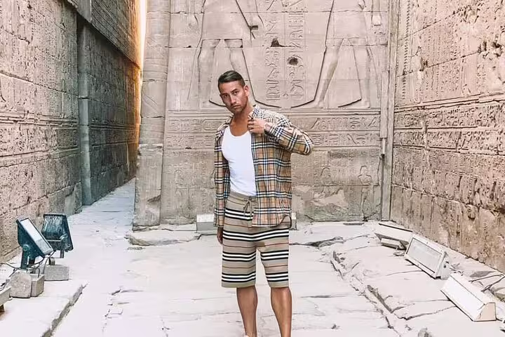 Traveler in ancient temple corridor in Luxor on private overnight tour from Cairo by flight, Egypt