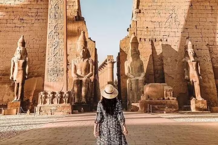Traveler at Luxor Temple entrance with colossal statues, private day tour from Safaga Port to royal tombs