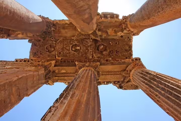 Upward view of carved stone columns at Luxor Temple on a private full-day tour from Safaga port