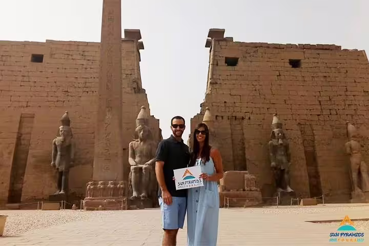 Couple posing by Luxor Temple with Ramses statues and obelisk, part of 8 days 7 nights Egypt Luxor Aswan tour