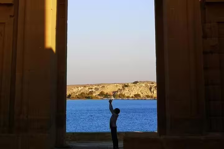 Traveler silhouette by the Nile framed by temple pillars on a full-day private Luxor tour from Safaga Port