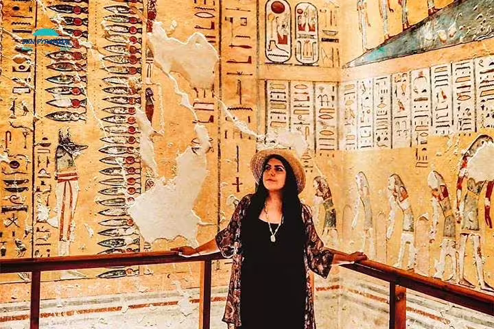 Traveler inside Luxor tomb with vivid hieroglyphic wall art on 8 days 7 nights Egypt Luxor Aswan tour