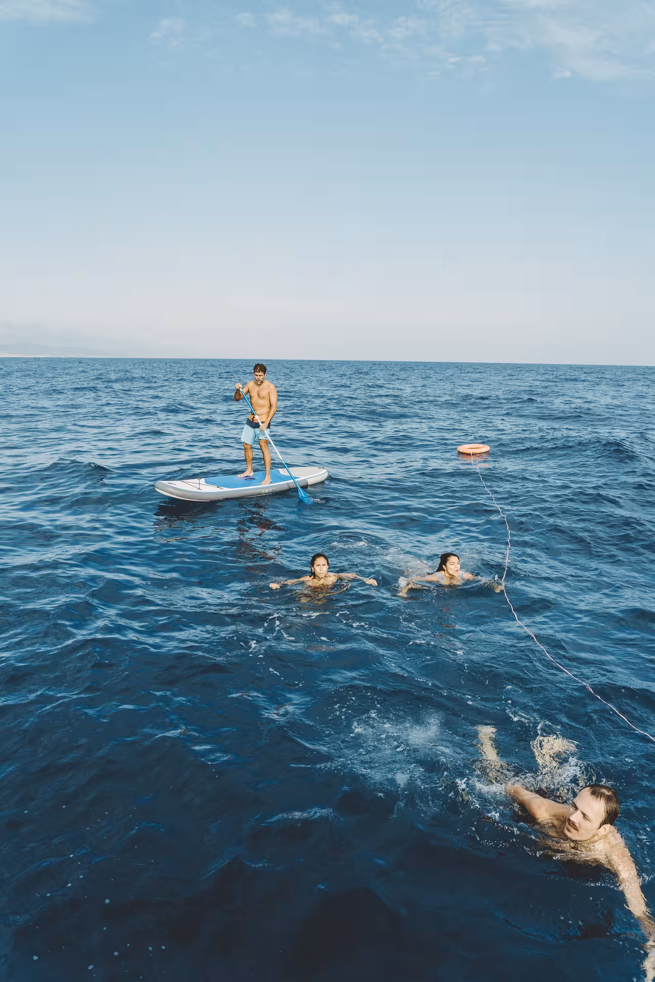Guests swimming and paddleboarding in the Mediterranean on a 2-hour private luxury catamaran Barcelona Bali 4.2