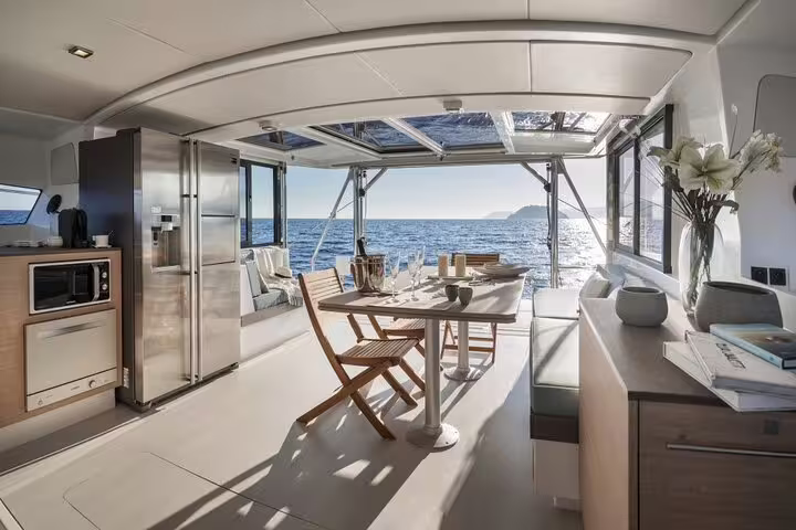 Luxurious catamaran interior with elegant dining setup and stunning sea views on a Cyprus tour from Limassol.