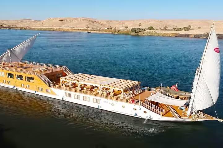 Luxury dahabiya Nile cruise boat with sun deck sailing past desert shores on a 5 days 4 nights Egypt itinerary