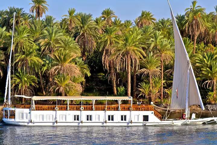 Luxury VIP Dahabiya moored on the Nile by palm-lined riverbank, Luxor to Aswan 4-night cruise