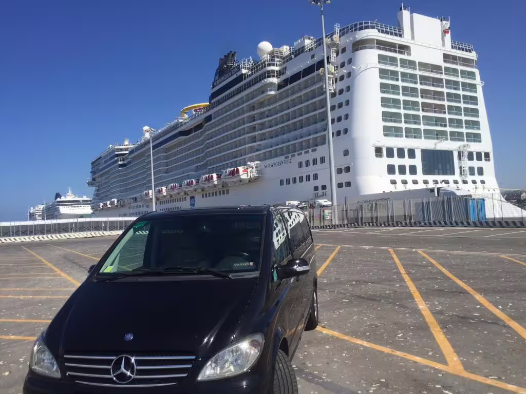 Luxury Mercedes minivan parked in front of a large cruise ship in Civitavecchia ready for private transfer to Fiumicino