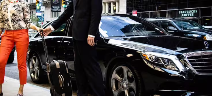 Chauffeur helping traveler with luggage into luxury Mercedes sedan for direct private transfer from Naples to Capri