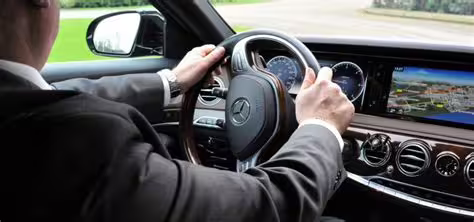 Professional chauffeur driving a luxury Mercedes sedan for private transfer service between Naples and Pozzuoli