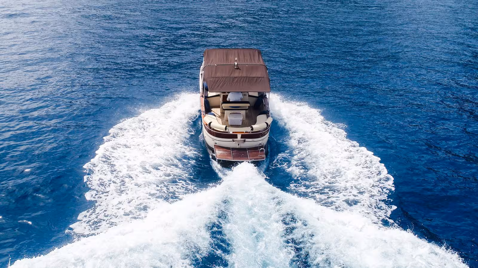 Luxury motorboat cruising through pristine blue waters on an exclusive Capri tour from Sorrento.