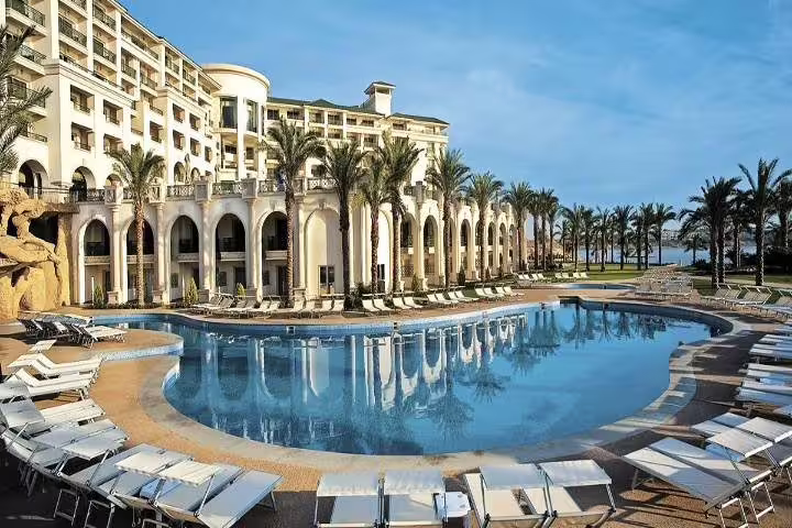 Luxury Red Sea resort pool with palm-lined loungers, relaxing stay on 4-day Cairo and Red Sea tour package