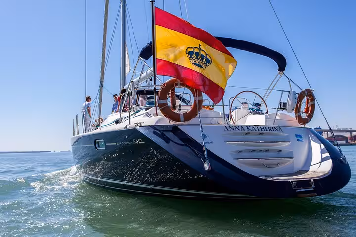Luxury sailboat with Spanish flag cruising off Barcelona, private sailing tour for up to 12 guests