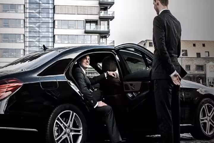 Luxury sedan with chauffeur assisting passenger, private Luxor Airport transfer with door-to-door hotel service