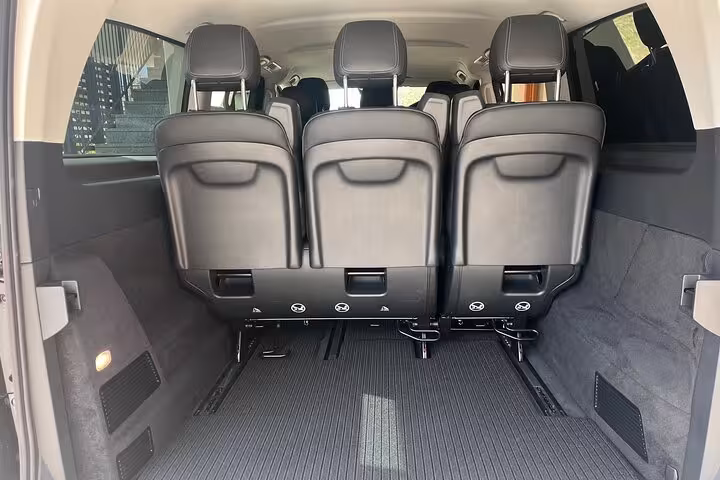 Spacious interior of a luxury van offering private transfers from Milan to Interlaken, showcasing comfortable seating.