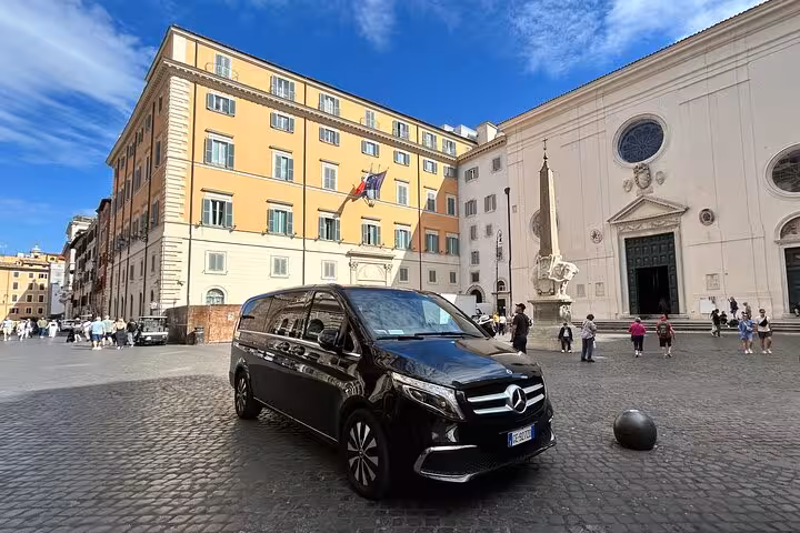 Luxury van parked in a historic Roman square, offering comfortable transport for the Rome Highlights Tour.