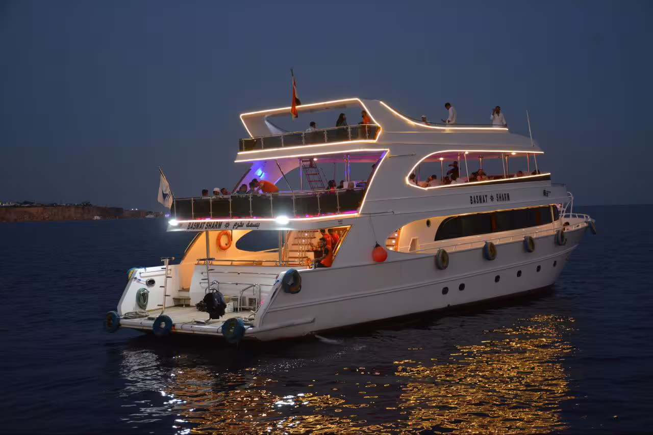 Luxury VIP dinner cruise boat sailing at night in Sharm El Sheikh, Red Sea, with lights and guests onboard