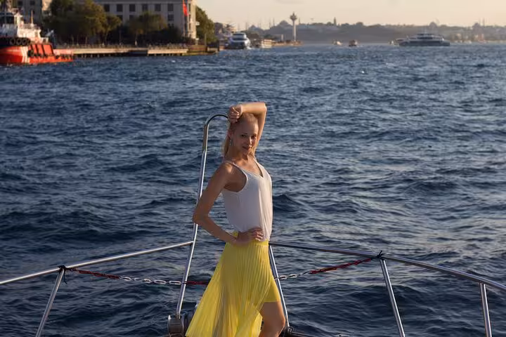 Woman posing on luxury yacht deck during private Bosphorus sightseeing cruise in Istanbul at sunset