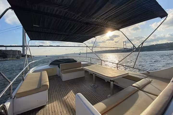Luxury yacht seating area with table on private Bosphorus cruise, Istanbul skyline and bridge views