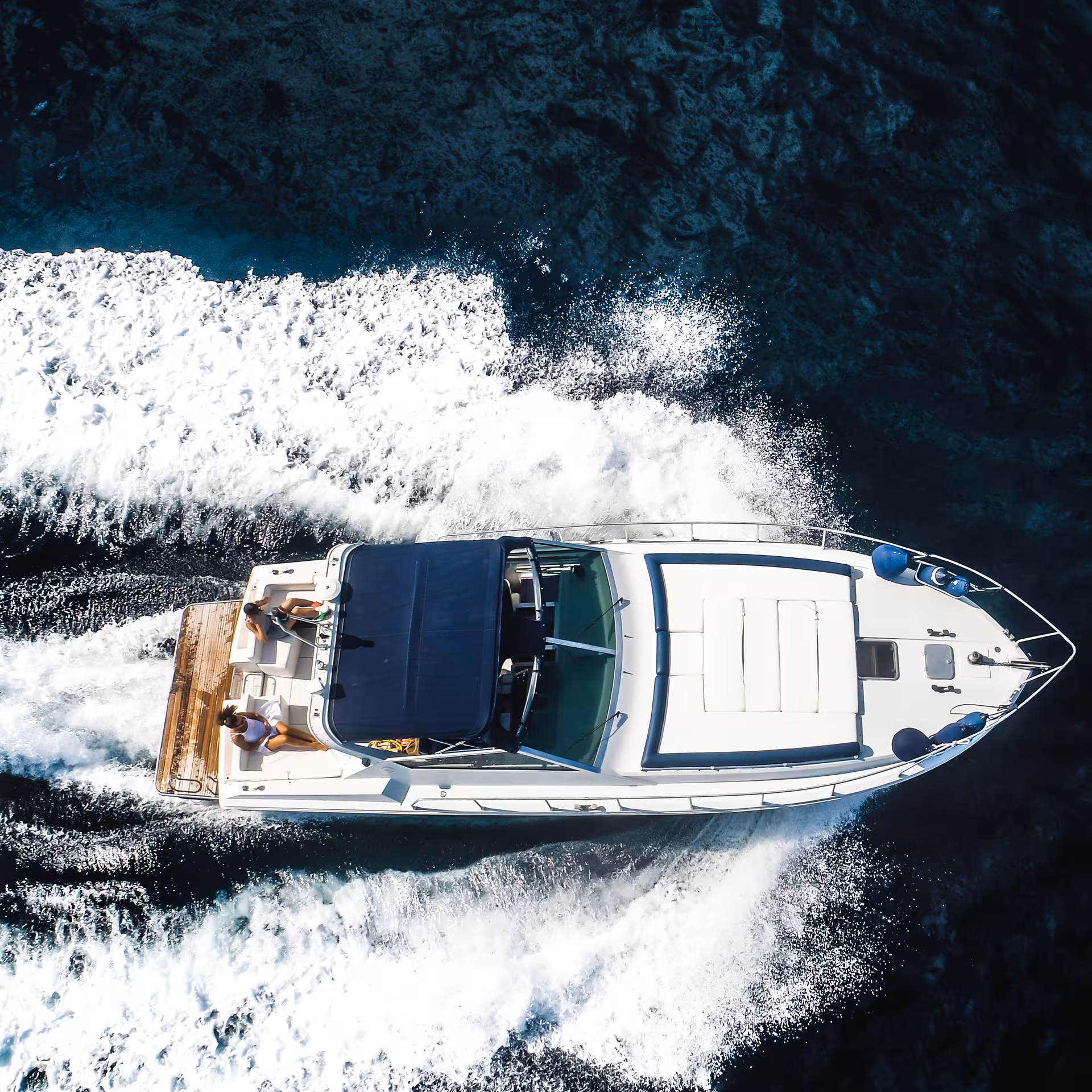 Aerial view of a luxury yacht cruising through the azure waters on a Capri boat tour from Sorrento.