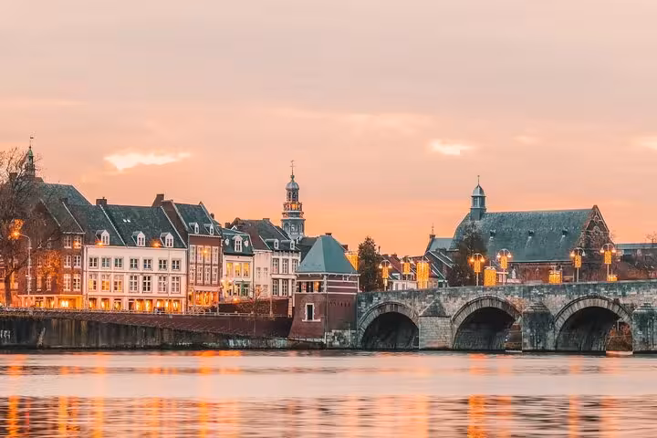 Evening lights on historic Maastricht bridge over the Maas, scenic highlight from Schiphol to Maastricht trip