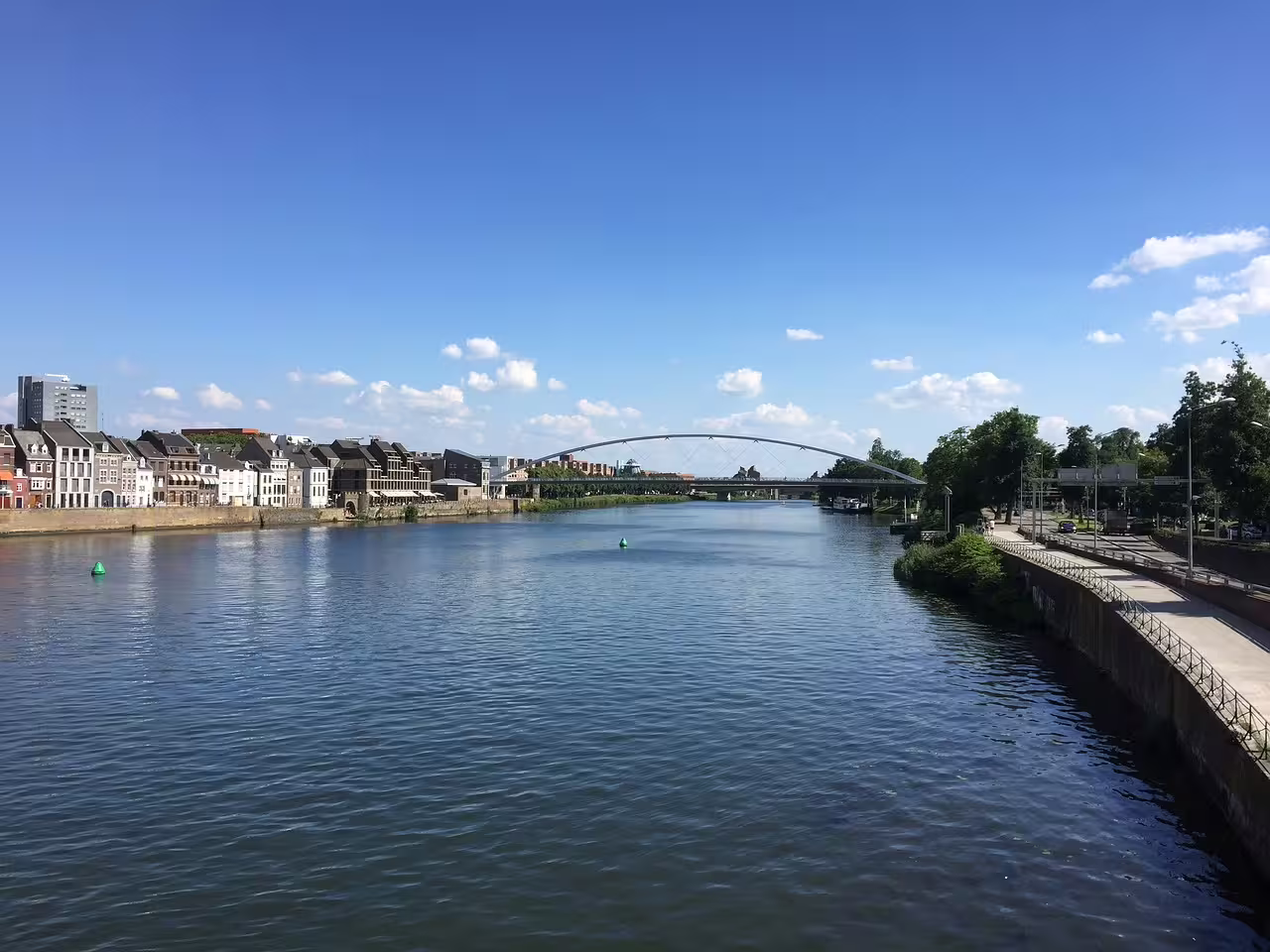 Maas River waterfront and modern arch bridge in Maastricht, scenic route for self-guided 1-day walking tour