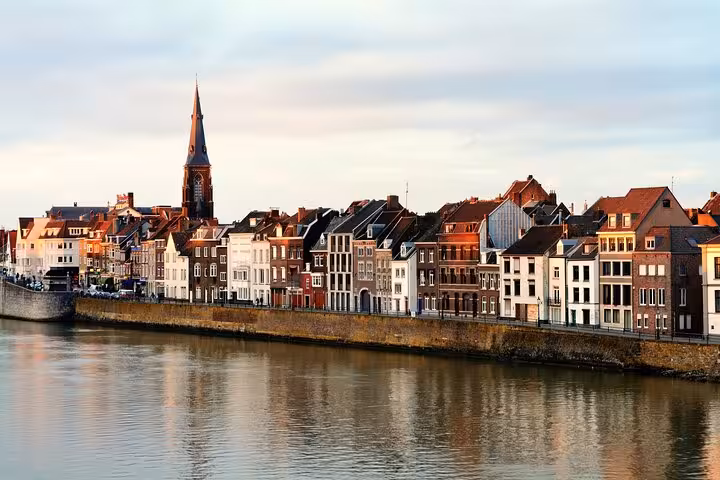 Colorful Maas River houses in Maastricht at sunset, featured on Amsterdam Airport Schiphol to Maastricht ride