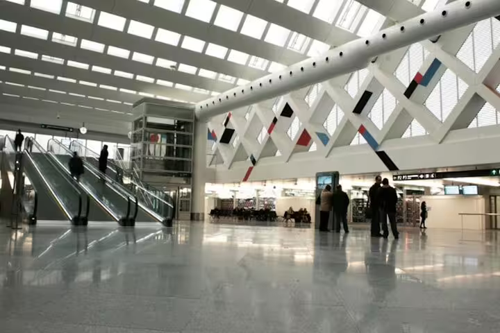Interior of Madrid Chamartín station concourse with escalators, meeting point for private transfer to Madrid
