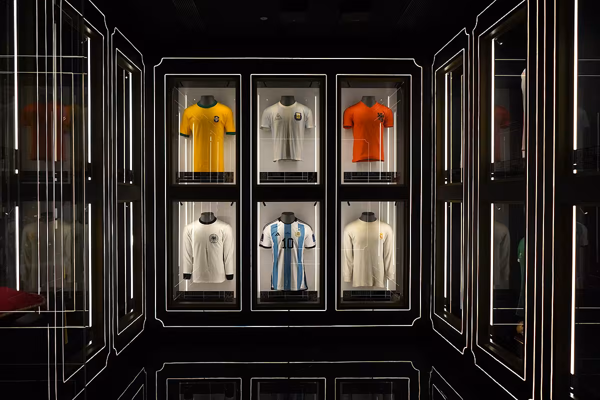 Football shirt museum display at Legends The Home of Football Madrid, showcasing historic jerseys in illuminated cases