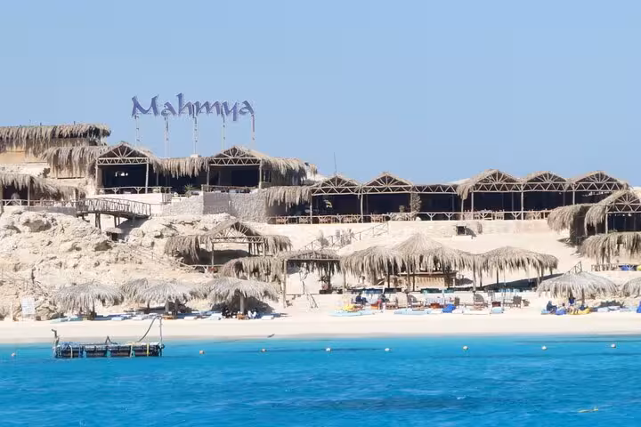Mahmya Island beach huts and sun loungers on turquoise Red Sea, stop on full-day snorkeling trip from Hurghada