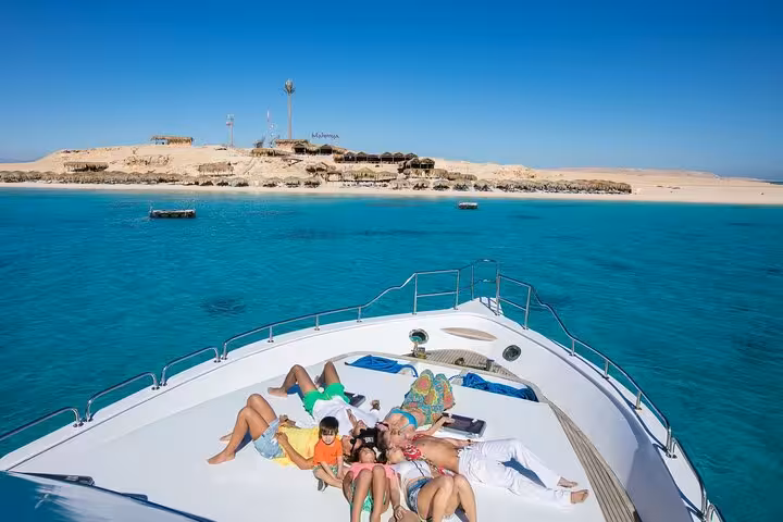 Family relaxing on yacht sun deck near Mahmya Island, Hurghada full-day snorkeling sea trip on clear Red Sea