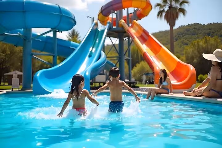 Kids playing in pool by colorful slides at Makadi Water World, Hurghada tour with lunch and transfers
