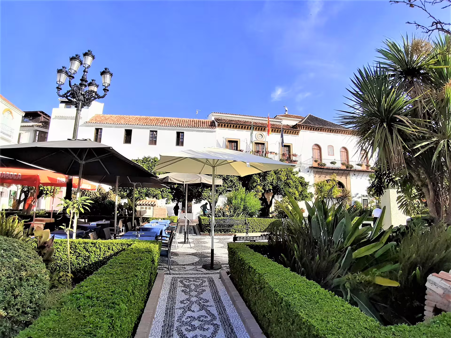 Private tour from Malaga to Marbella showing Plaza de los Naranjos gardens and café terraces in the old town