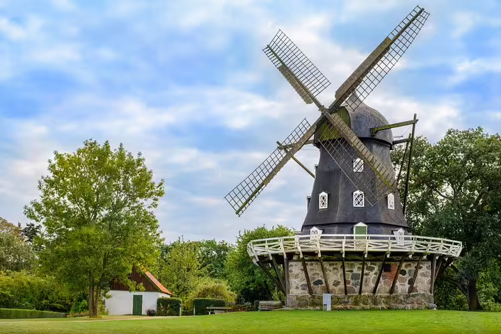 Historic windmill surrounded by lush greenery in Malmö, Sweden, featured on a full-day private train tour from Copenhagen.