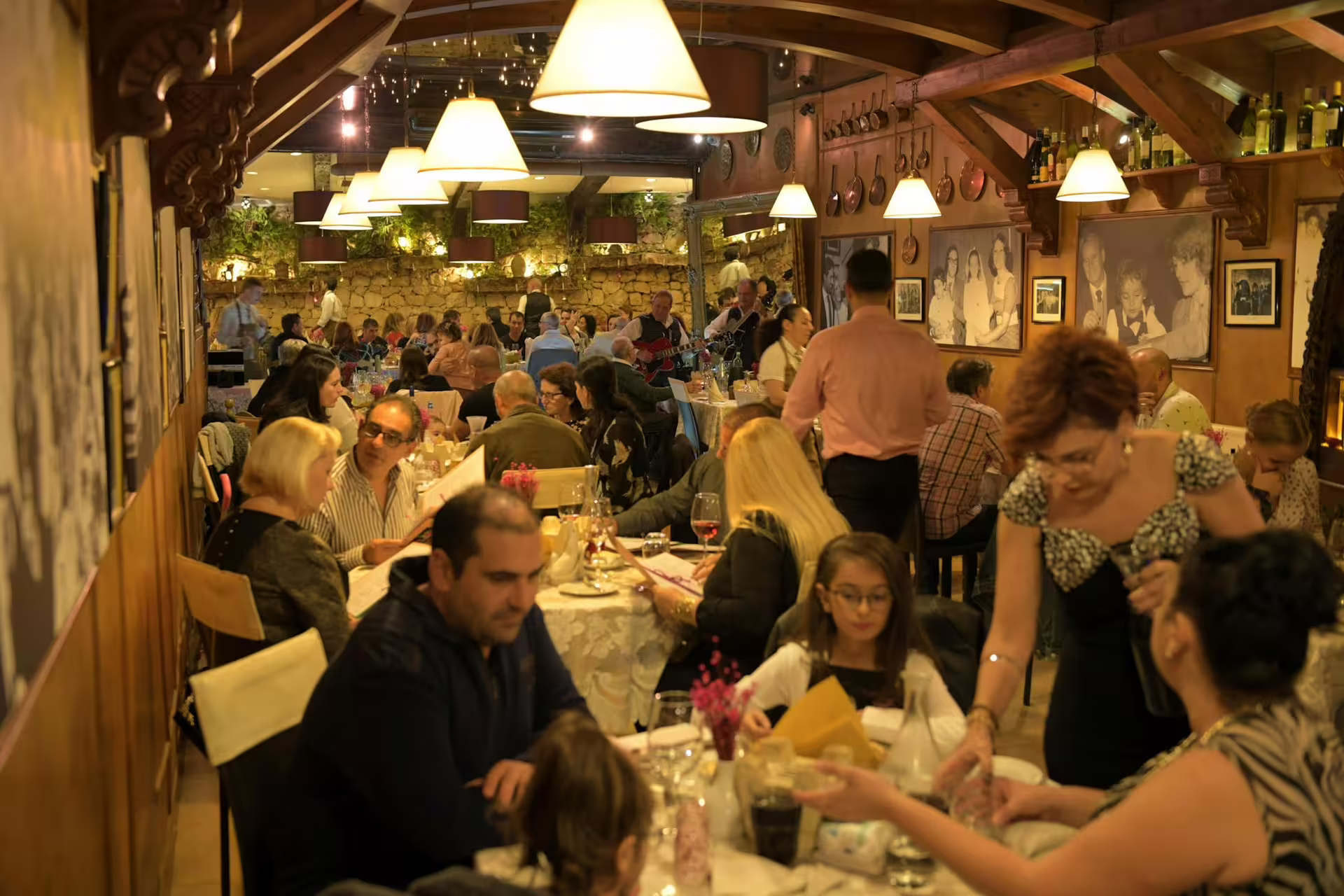 A vibrant dining room filled with guests enjoying a Maltese folklore night tour with authentic cuisine and music.
