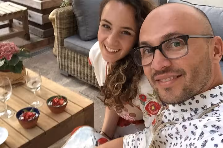 Smiling couple enjoying Italian aperitif experience with wine glasses and snacks at MaMa Florence tour.